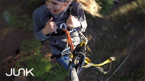 Image of woman on rope swing screaming, junk logo on bottom left